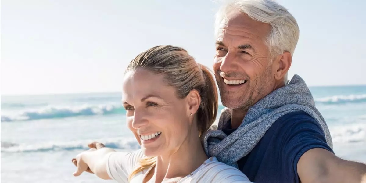 Senioren genießen den Strand mit ihren Implantaten im Alter
